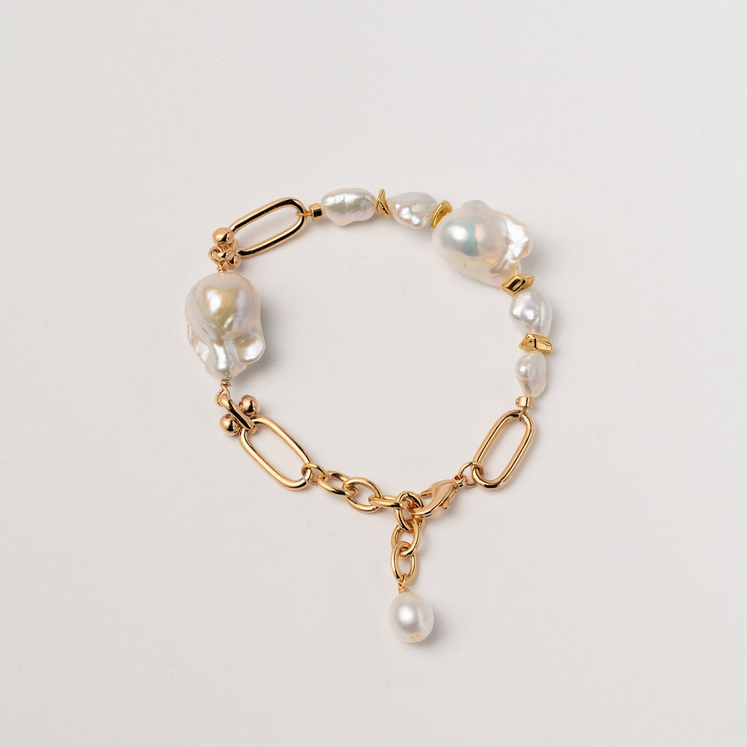 a gold filled bracelet with two large baroque pearls and four small keshi pearls. There is a teardrop pearl attached to the end of the extender. The clasp is a lobster clasp.