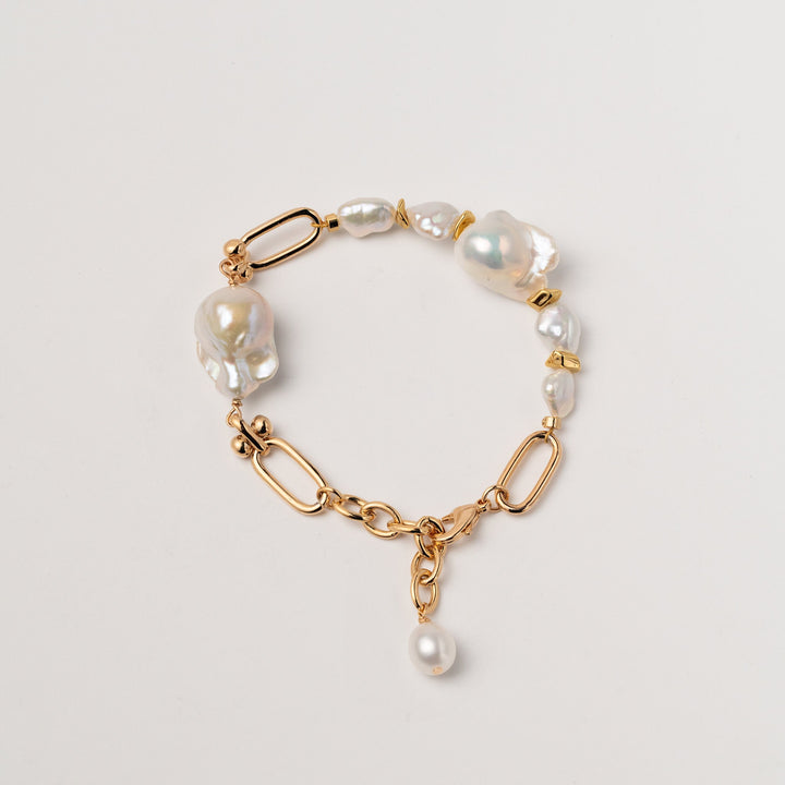 a gold filled bracelet with two large baroque pearls and four small keshi pearls. There is a teardrop pearl attached to the end of the extender. The clasp is a lobster clasp.