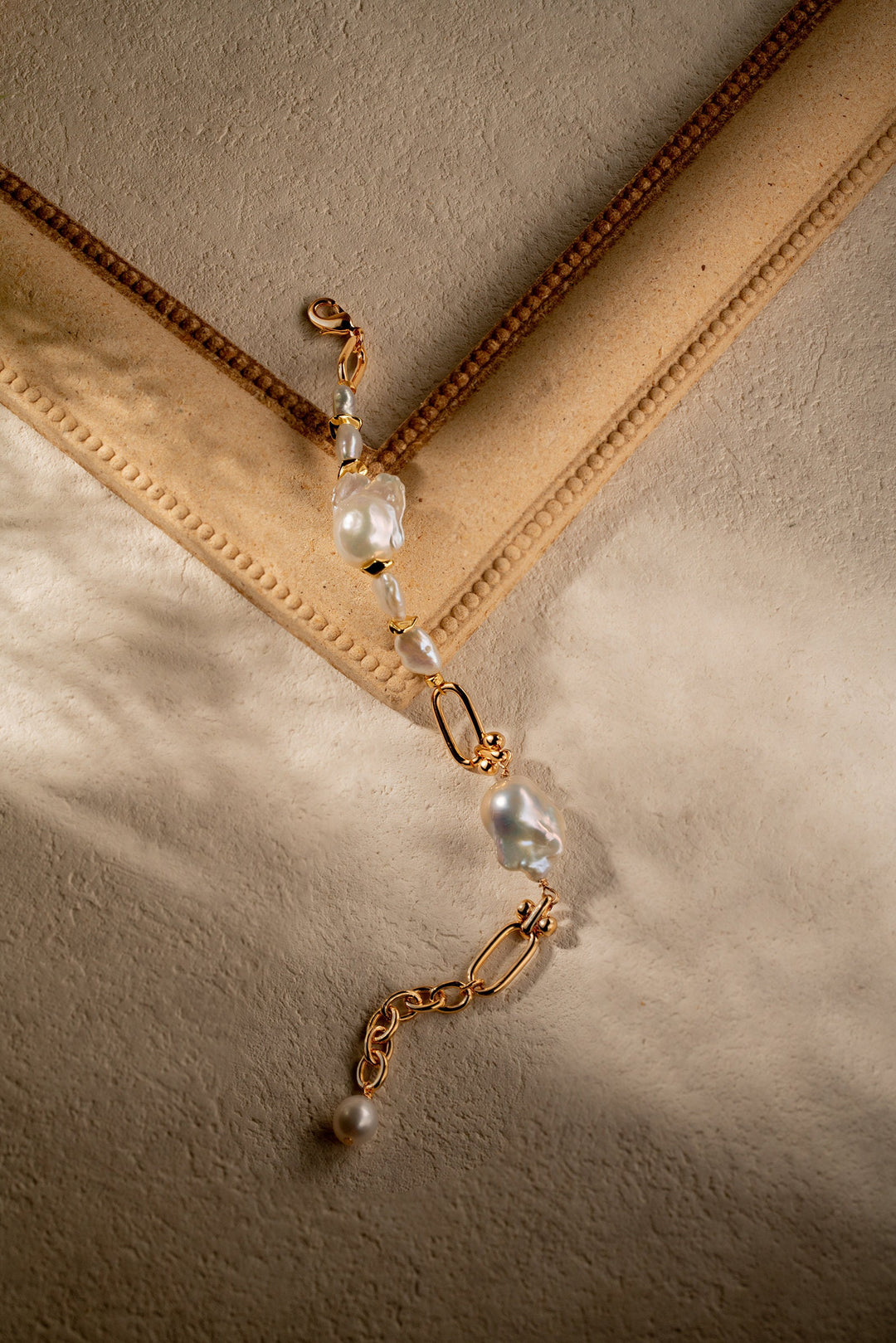 a gold filled bracelet with two large baroque pearls and four small keshi pearls. There is a teardrop pearl attached to the end of the extender. The clasp is a lobster clasp.