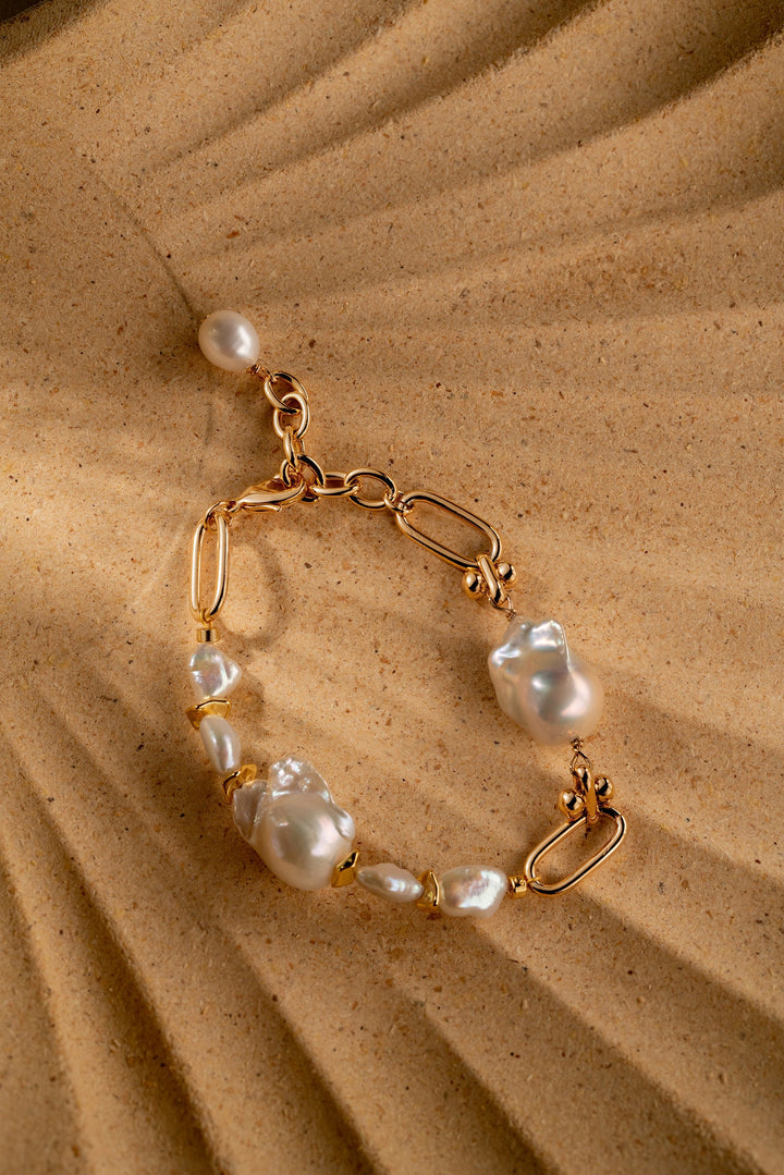 a gold filled bracelet with two large baroque pearls and four small keshi pearls. There is a teardrop pearl attached to the end of the extender. The clasp is a lobster clasp.